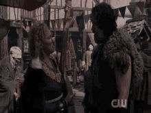 a man and a woman are standing next to each other in a scene from a tv series .