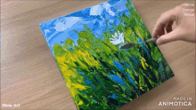 a person is painting a field of flowers with a spoon