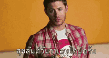 a man in a plaid shirt is holding a bouquet of flowers in a foreign language .
