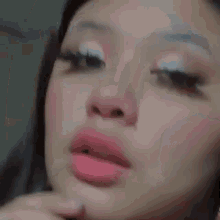 a close up of a woman 's face with a pink lip and white eyeshadow .