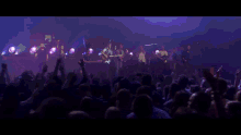a crowd of people with their arms in the air at a concert