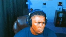 a man wearing headphones is sitting in a chair looking at the camera