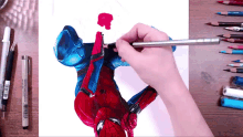 a person is drawing a picture of spider man with a pencil