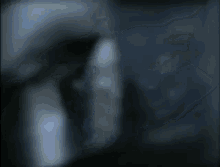 a man wearing a hat and a backpack is walking in the dark .