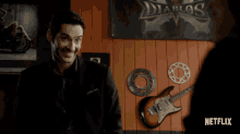 a man in a suit is smiling in front of a sign that says diablo 's