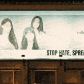 a billboard with a picture of a group of women and the words stop hate spread