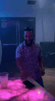 a man with a beard wearing a floral shirt is smiling