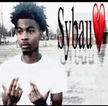 a young man is giving the middle finger in front of a sybau logo
