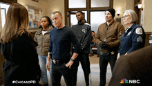 a group of people standing in a room with a chicagopd logo in the corner