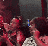 a group of people are sitting in a dark room with a can of pepsi on the table .