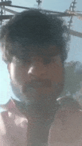 a man with a beard is taking a picture of himself with a phone .