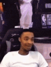 a man in a white shirt is sitting in front of a screen that says nba finals
