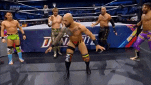 a group of wrestlers are standing in a ring .
