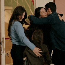 a man kisses a woman on the forehead while a woman looks on