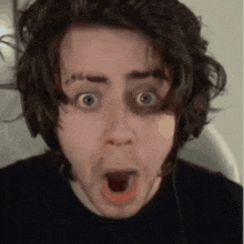 a man with a surprised look on his face is wearing headphones .