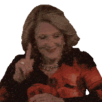 an elderly woman wearing a red floral shirt is smiling and pointing up