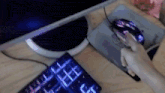a person is using a computer mouse next to a keyboard that has the letter e on it