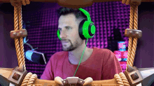 a man wearing green headphones is sitting in front of a microphone in a pirate ship .