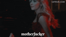 a woman in a red dress is saying motherfucker in a dark room