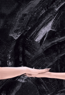 a woman 's hand is reaching out towards another woman 's hand