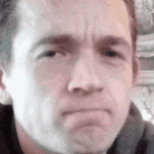 a close up of a man 's face with a serious expression .
