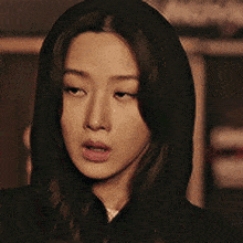 a close up of a woman wearing a black hooded jacket .