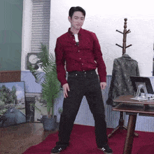 a man in a red shirt and black pants is dancing