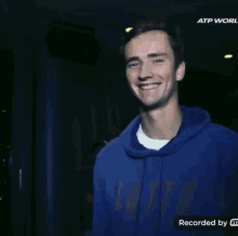a man wearing a blue lotto sweatshirt giving the peace sign