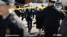 a man in a suit is surrounded by police tape and a nbc logo on the bottom right