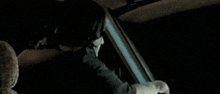 a man and a woman are sitting in a car with an alien behind them .