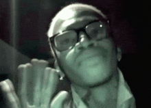 a man with glasses and a beard is looking up at something