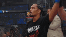 a man wearing a black shirt that says always holds his hand up in the air