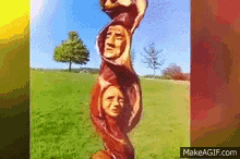 a picture of a tree trunk with faces carved into it is displayed on makeagif.com