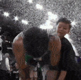 a basketball player is kneeling down in front of a crowd with his hands on his knees
