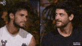 two men are standing next to each other in a dark room .