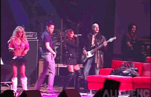 a group of people on a stage with a red couch in the foreground that says alignment