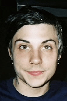 a young man with a nose ring is smiling for the camera
