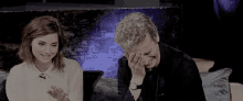 a man and a woman are sitting next to each other on a couch .