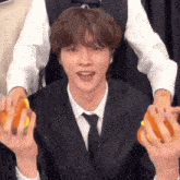 a man in a suit and tie is holding a hamburger in his hands .