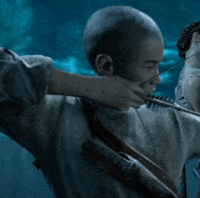 a man with a shaved head is holding a rifle