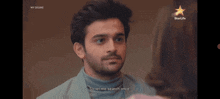a man in a turtleneck sweater is talking to a woman in a star life ad