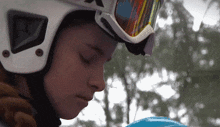 a close up of a person wearing a helmet and goggles with the letter x on it