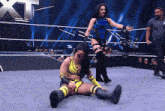 two women are wrestling in a ring with a w logo in the back