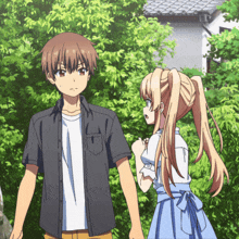 a boy and a girl are standing next to each other in a garden