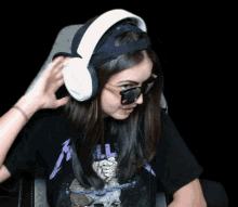 a woman wearing headphones and sunglasses with a black shirt that says metallica