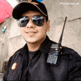 a man wearing sunglasses and a hat has a walkie talkie on his shoulder