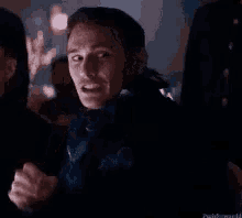 a man in a blue jacket is making a funny face