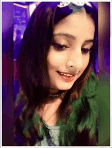 a girl with green hair and a tiara on her head smiles