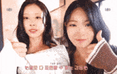two girls are giving each other a thumbs up in a room