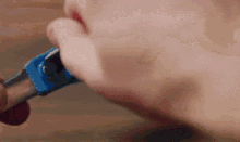 a close up of a person 's mouth holding a blue object